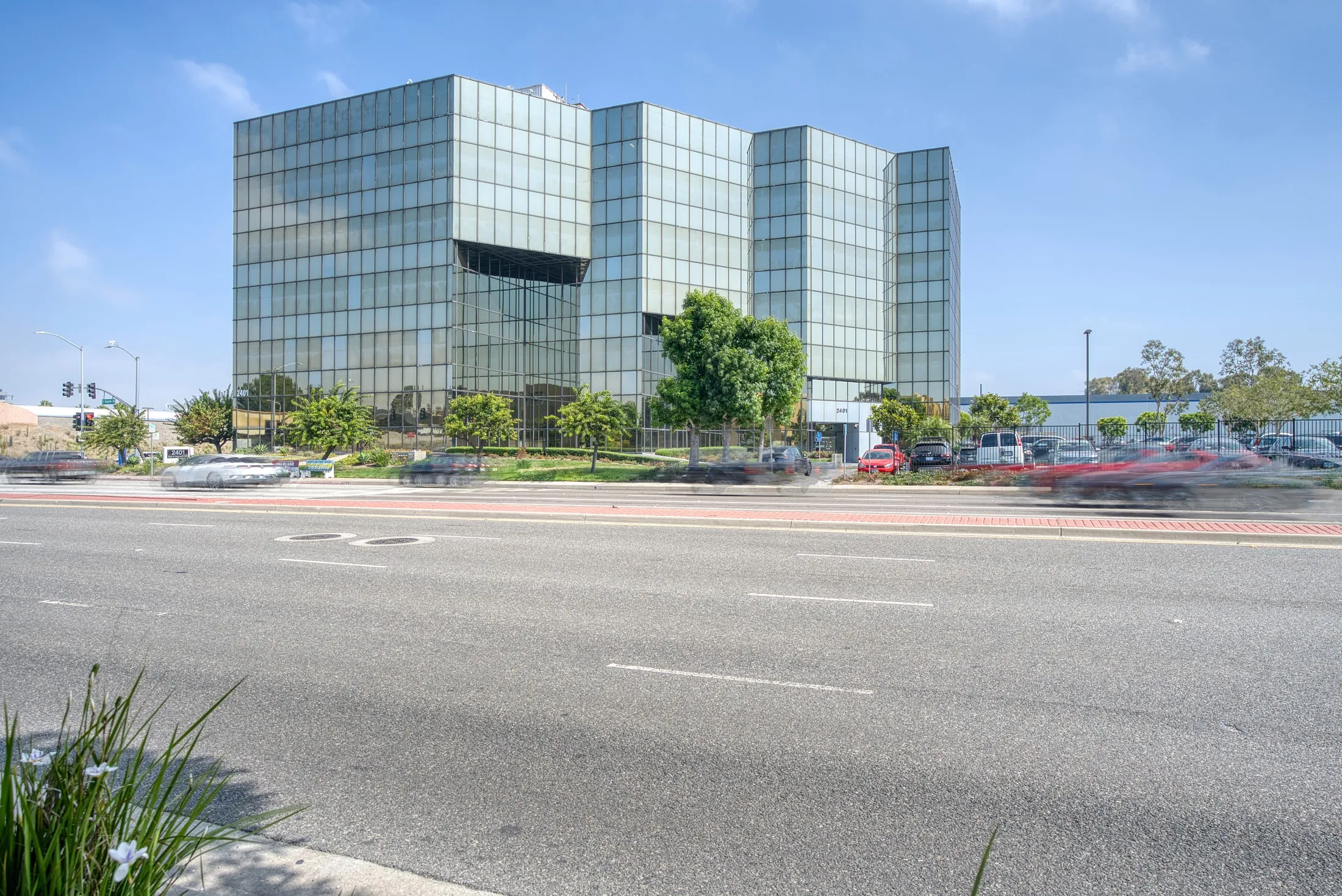 Street-level view of 2401 E. El Segundo Blvd framed by trees, El Segundo, California.