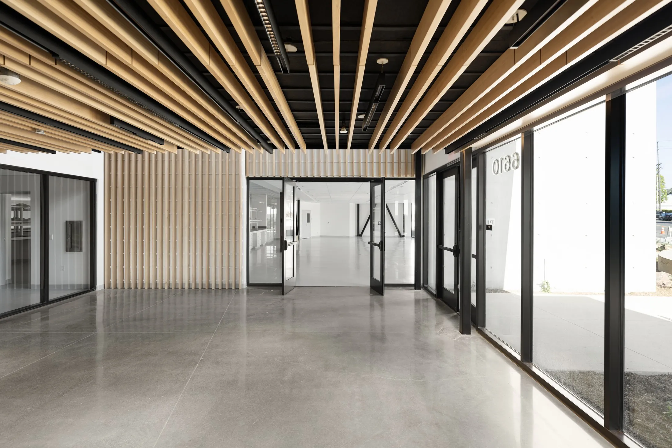 Lobby interior with wood-slat ceiling and glass entry doors