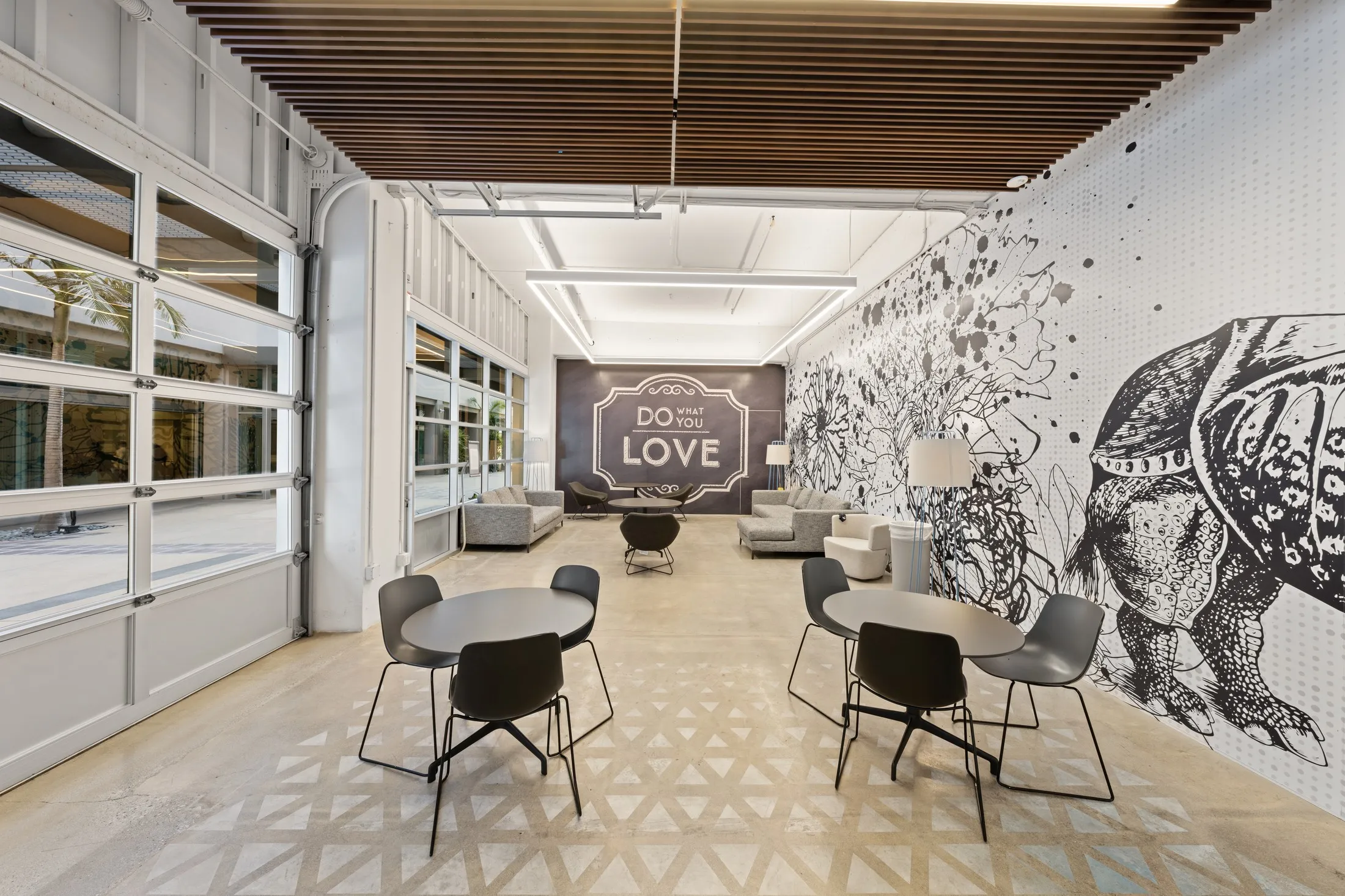 The tenant lounge, "the garage," with a line-drawn rhino and floral mural and a "Do What You Love" sign