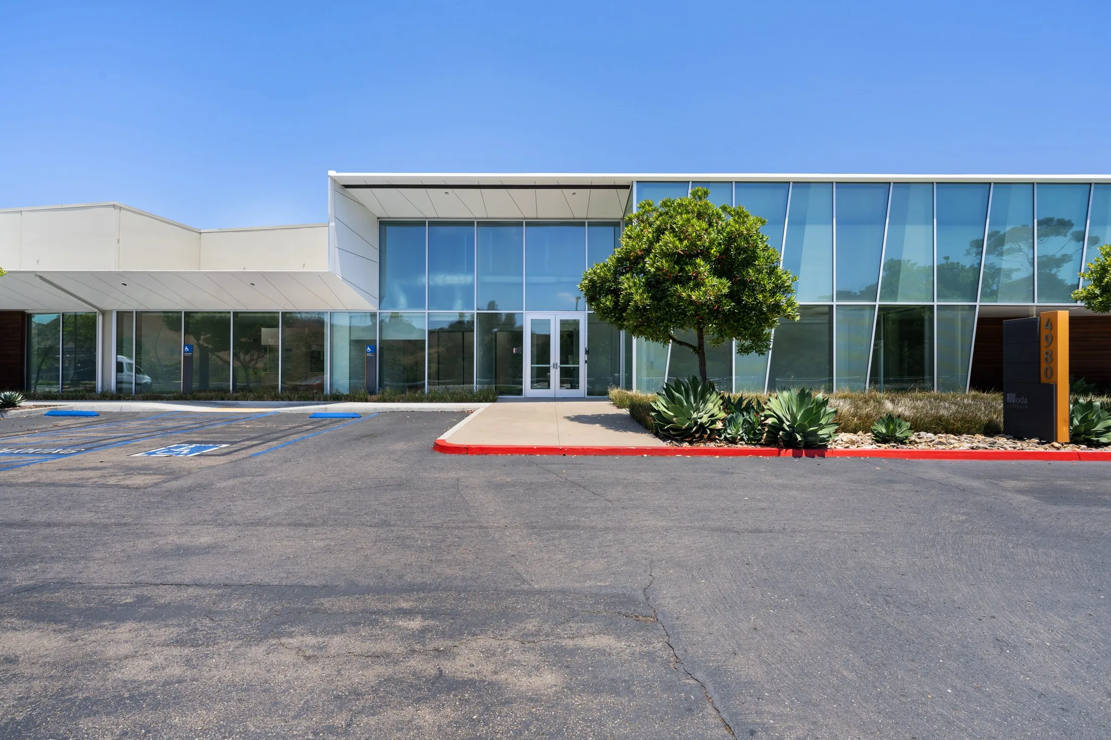 Glass entrance at 4980 with the Moda Sorrento monument sign