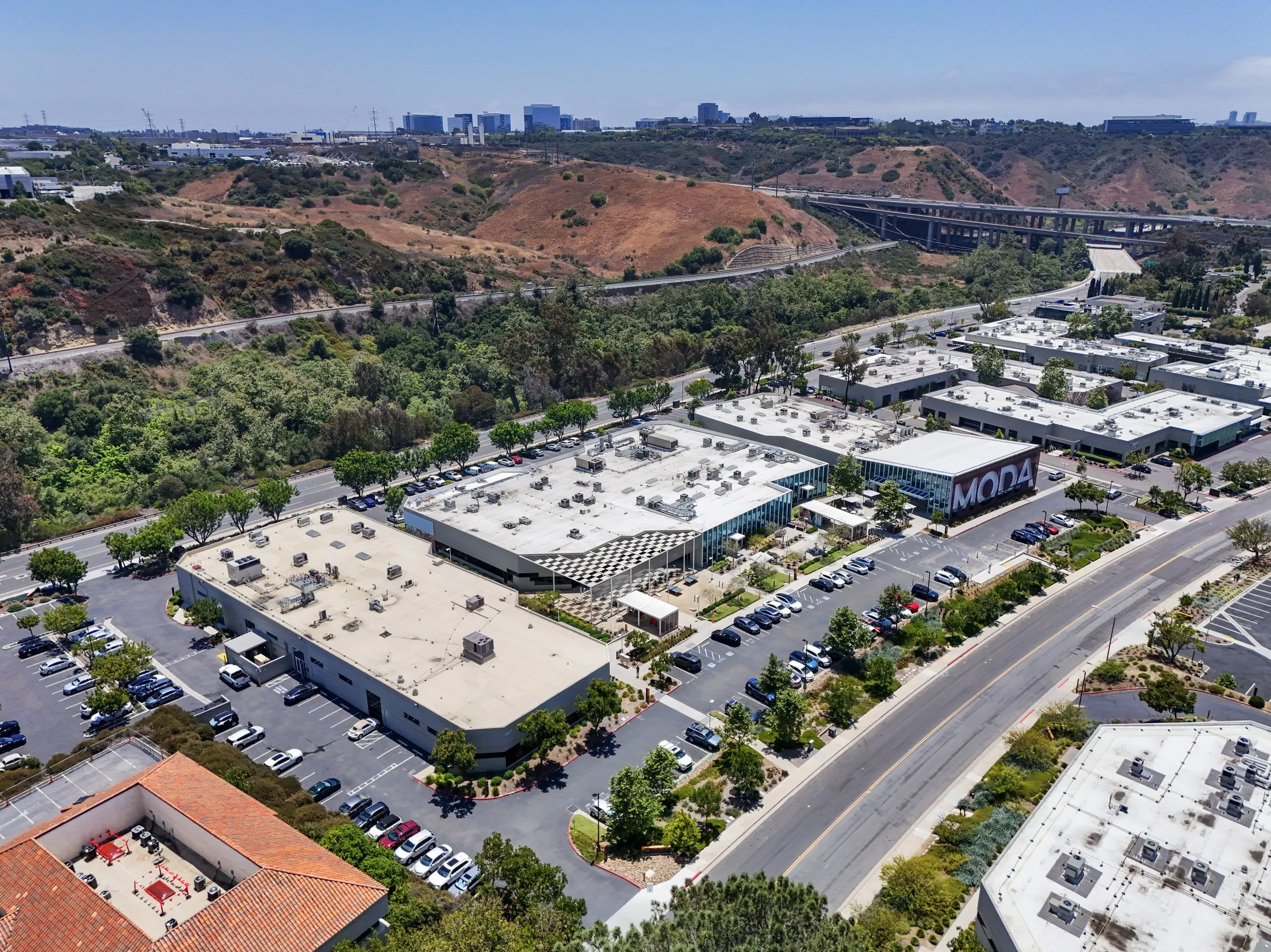 Aerial view of the MODA Sorrento campus with the hillside and freeway behind it